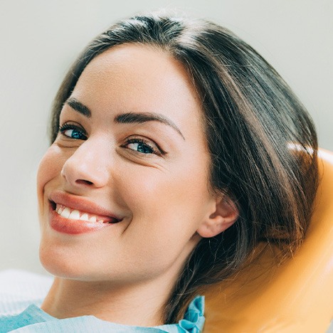 A woman smiling in a dental chair
