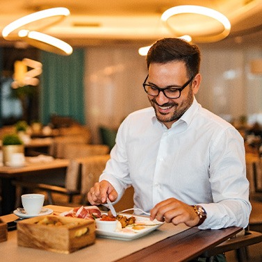 Man smiling while enjoying meal at restaurant