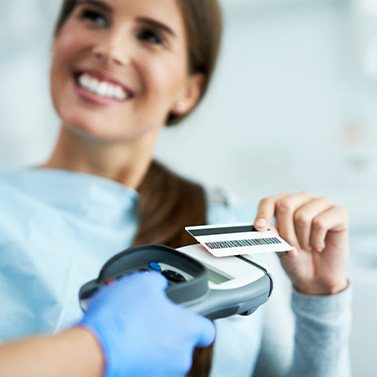 A woman paying for cosmetic dentistry