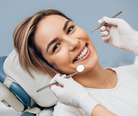 Smiling woman receiving comprehensive dental care