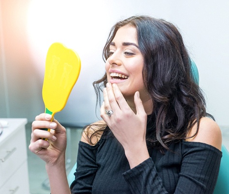 Woman looking at her smile in mirror.