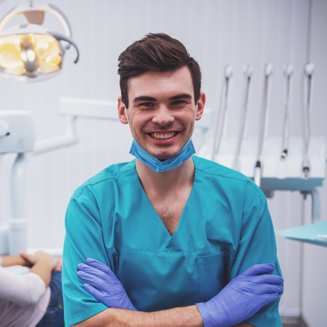 Dentist in medical scrubs smiling