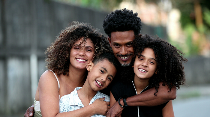 Family of four gathered outside and smiling