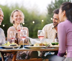 a mature couple with dentures eating with friends