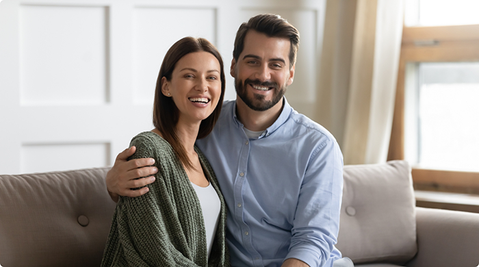 Man and woman sitting on couch smiling