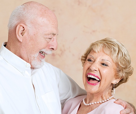 Man and woman with dentures smiling