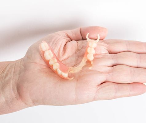 Hand holding a partial denture