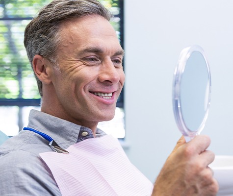 Man looking at smile after denture stabilization