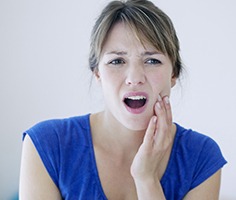 Woman with lost filling holding jaw
