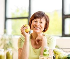 smiling woman holding an apple