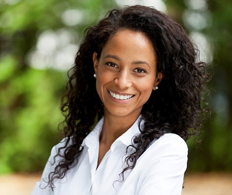 Woman smiling outside with dental implant dentures in Lancaster