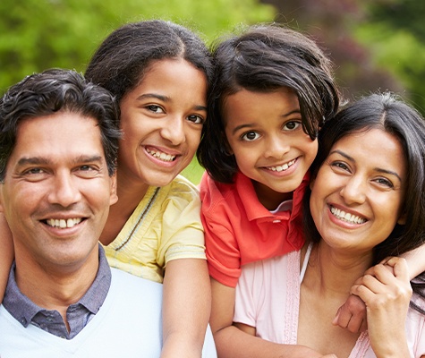 Mother father and two children smiling after preventive dentistry