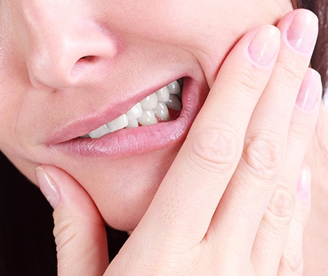 Patient holding jaw in pain after tooth extraction