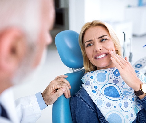 Woman talking to dentist about painful toothache