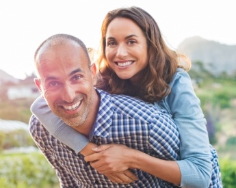 Man and woman smiling after restorative dentistry