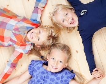 Three children smiling after children's dentistry visit
