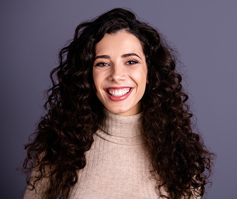 Woman smiling after porcelain veneer treatment