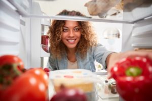 person getting food out of their refrigerator 