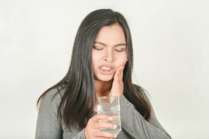 Woman drinking water with tooth sensitivity in Lancaster