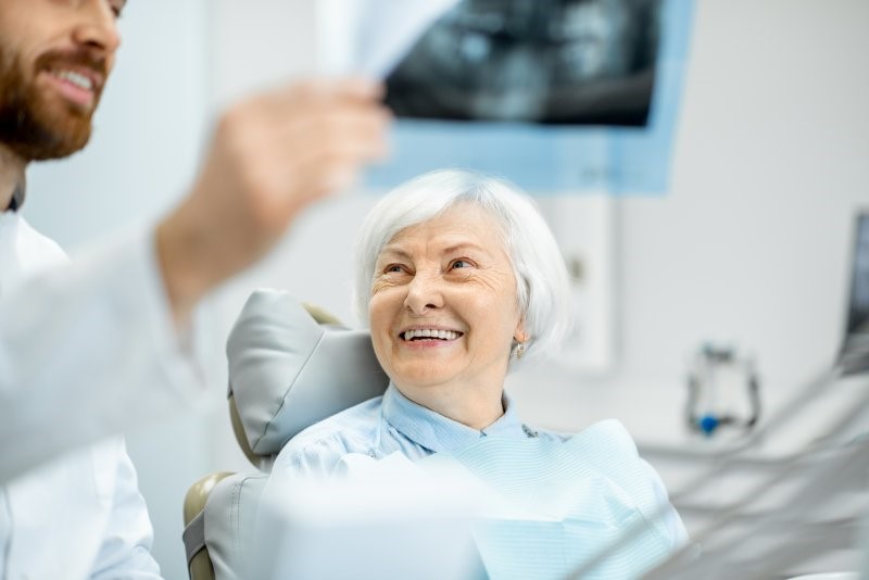 person talking with dentures to dentist