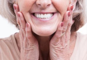a woman with healthy dentures due to good habits
