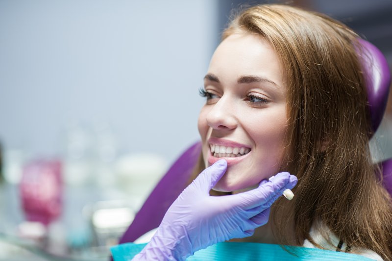 A woman getting her dental crown checked at the dentist