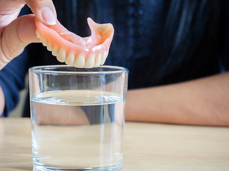 A person taking care of their dentures