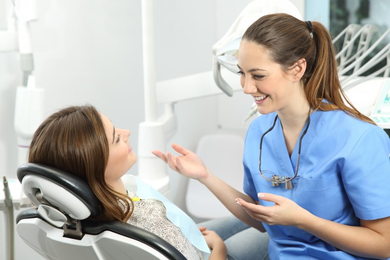 person speaking with dentist about dental implants