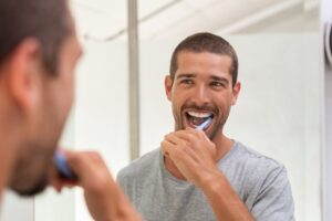 Man brushing his teeth with new toothbrush