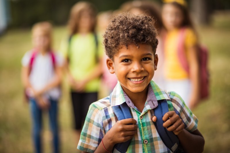 little boy with backpack smiling 